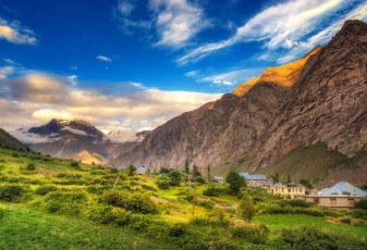 Los campos verdes contrastan con las escarpadas montañas del valle de Lahaul, en Himachal Pradesh. El pueblo de Jispa, al pie de las montañas © structuresxx