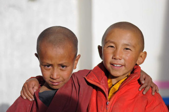 Dos jóvenes monjes budistas se cogen de la mano en el exterior del monasterio de Thiksey, Leh, India © Pavel Svoboda