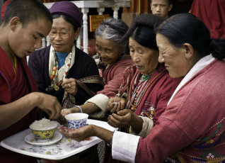Devotos aceptan comida bendita en el antigüo monasterio budista - Imagen de Daniel J Rao