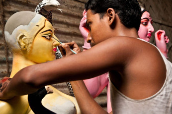 Un artesano dibuja los ojos de las diosas el 14 de agosto de 2011 en Kumartuli, Calcuta, India. Estos ídolos están hechos para el festival bengalí de la diosa Durga Puja también conocida como Dassera - Imagen de Neelsky