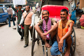 Dos trabajadores en una bicitaxi tirada a mano sonríen durante la hora de descanso en la calle. El "Espacio de la vía" de Calcuta es sólo el 6% frente al 23% en Delhi y el 17% en Mumbai - Imagen de Radiokafka