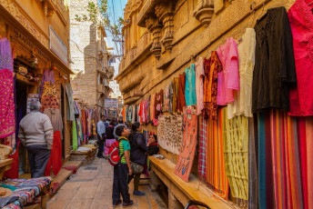 Colorido callejón repleto de tiendas en el interior del fuerte de Sonar, en Jaisalmer. El fuerte también es conocido como la “Fortaleza dorada” debido a su arenisca amarilla que adquiere un color miel dorado al ponerse el sol.