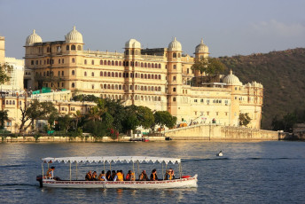 Los visitantes de Udaipur admiran el Palacio de la ciudad desde un barco en el lago Pichola. El complejo palaciego fue construido a lo largo de 400 años por los sucesivos gobernantes de Mewar y es el más grande de Rajastán.