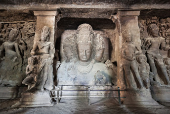 Escultura de piedra de tres cabezas del Señor Shiva en las cuevas de la isla Elephanta, cerca de Mumbai, en el estado de Maharashtra, India © saiko3p / Shutterstock