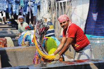 Un hombre lavando ropa en el distrito de lavandería Dhobi Ghat, que es una conocida lavandería al aire libre en el centro de Mumbai. © Wantanddo