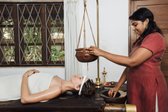 Mujer teniendo un tratamiento de rejuvenecimiento de Ayurveda shirodhara de la India, Kerala - Imagen de Nina Lishchuk
