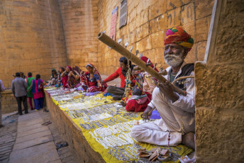Lugareños dentro del fuerte de Jaisalmer vendiendo productos de joyería, mientras un anciano toca el instrumento musical rajasthani llamado ravanhatha, Jaisalmer, Rajasthan, India © Prabhjit S. Kalsi / Shutterstock