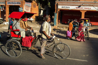 Conductor de bicitaxi transportando pasajeros a través de la parte antigüa de Jaipur - Imagen de Alexander Mazurkevich