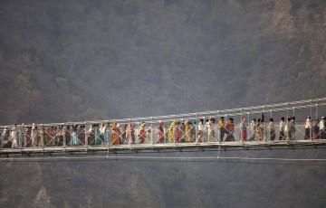 Muchedumbre de peregrinos hindúes cruzando el puente Laksman Jhula en Rishikesh - Imagen de ozgurdonmaz