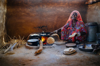 Mujer prepara la comida en casa de barro en el área rural de Rajasthan - Imagen de Costas Anton dumitrescu