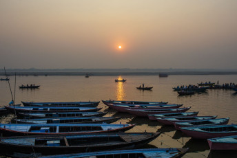 Amanecer entre los barcos en Varanasi. Los rayos del sol forman un camino en las aguas del río Ganges © Mikhail Ivannikov/ Shutterstock