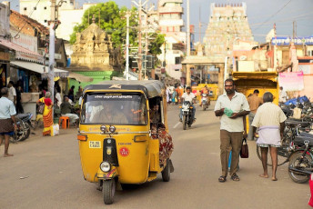 Bullicioso tráfico callejero en la ciudad del templo de Madurai con el Templo Meenakshi al fondo.