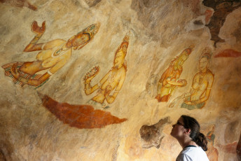 Una mujer visita las Damiselas de Sigiriya, los frescos más icónicos de Sri Lanka que se encuentran a medio camino de Lion Rock, Sri Lanka ©