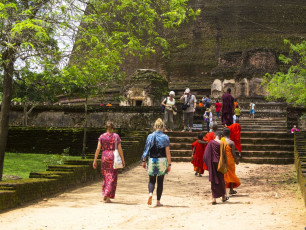 Turistas y monjes jóvenes caminando por las ruinas de Polonnaruwa, Sri Lanka © DavorLovinic