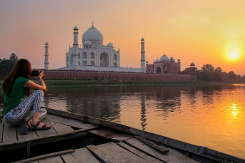 Mujer contempla la puesta de sol sobre el Taj Mahal desde un bote en Agra, India. El Taj Mahal fue construido en 1632 por el emperador Shah Jahan en homenaje a su segunda esposa, Mumtaz Mahal. © Don Mammoser / Shutterstock
