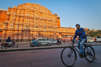 Hombre indio montando en bicicleta frente al Palacio Hawa Mahal en Jaipur, Rajasthan - Imagen de F9photos