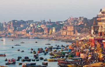 Una vista matutina fascinante del río Ganges con escalones que conducen al agua donde los barcos están abarrotados en los Ghats de Varanasi en Varanasi, India