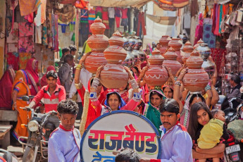 Una banda lleva a las mujeres que llevan cuencos simbólicos en sus cabezas en una procesión por las calles de la ciudad de Rajastán como parte de la celebración de bodas hindúes tradicionales - Imagen de pjhpix
