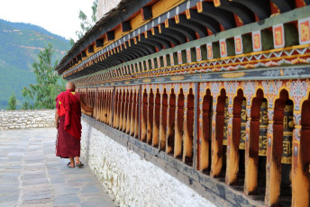 Viejo lama girando las ruedas de oración en Lhakhang Changangkha, monasterio del budismo tibetano del siglo XII en Thimphu, Bhutan © Louis W / Shutterstock