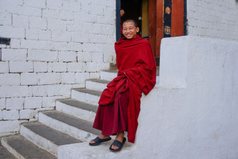 Joven monje budista con túnicas tradicionales en Trashi Chhoe Dzong, Bhutan © angela Meier / Shutterstock
