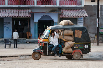 Bicitaxi indio con conductor lleno de bolsas en la carretera, Orchha - Imagen Elena Mirage