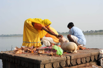 Gente realizando Pooja en la mañana en ghats sagrados del río Narmada en Maheshwar, India. Para los hindúes, el Narmada es uno de los 5 ríos sagrados de la India - Imagen de Stefano Em