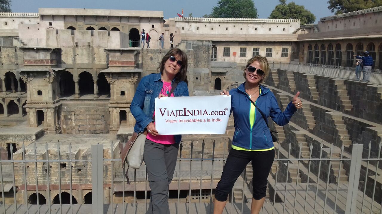 La familia Andrea Susanna y Alejandra Meleghelli, de Argentina, posando con la pancarta de nuestra empresa delante de Abhaneri Stepweel en India