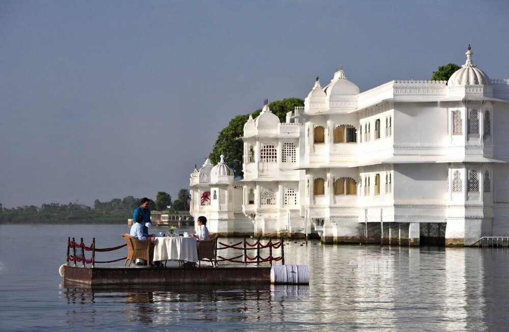 Turistas disfrutando de un desayuno privado especial en el lago Pichola en Udaipur Rajastán, organizado por el hotel Taj Lake Palace